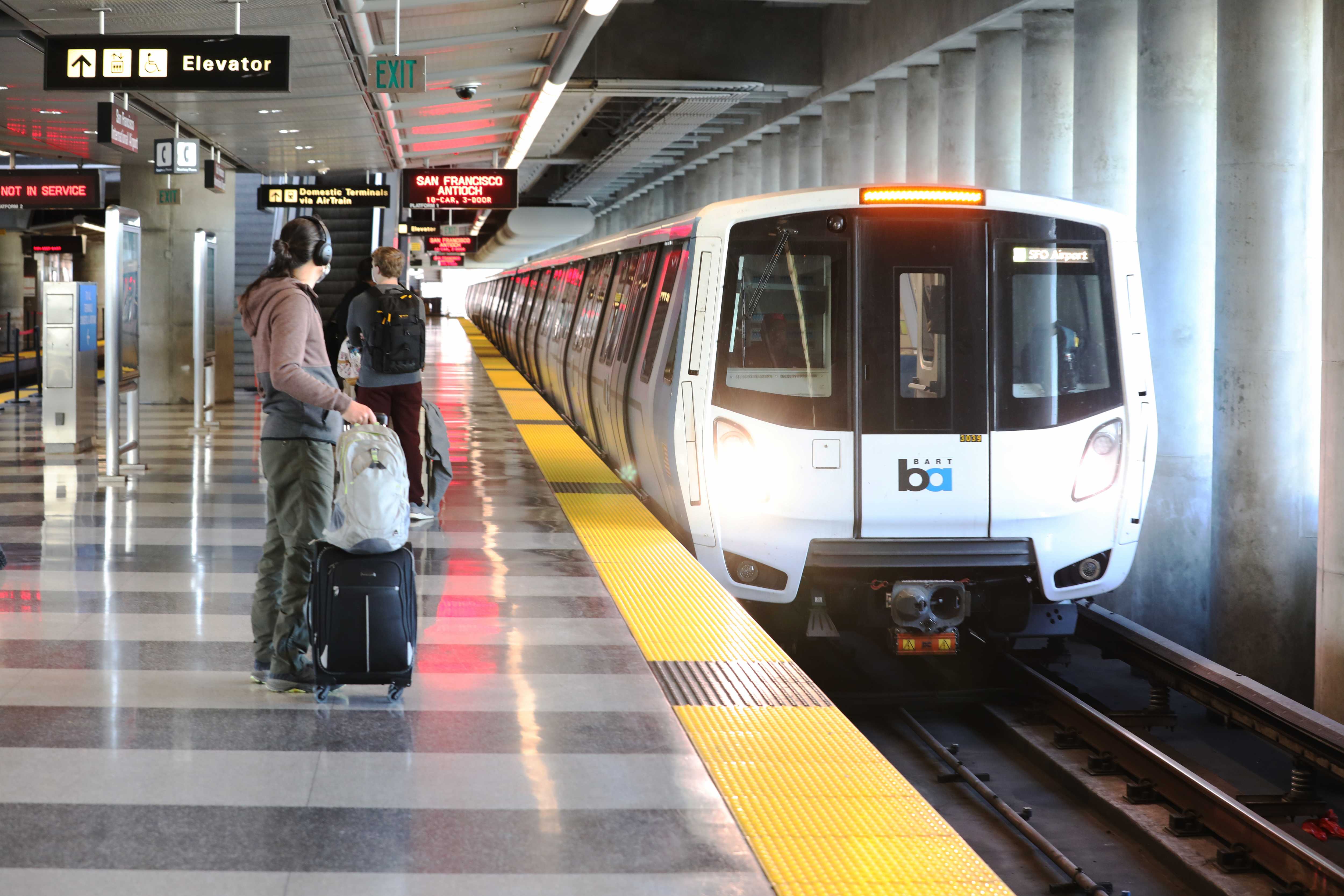 A BART rider with luggage at SFO station