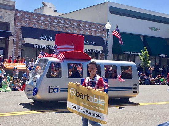 Jiahao Huang carries a sign beside BARTmobile