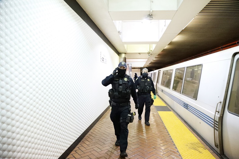 Officers Nathan Young (foreground) and Eric Hofstein (now retired) help with homeless outreach. Photo by Maria J. Avila, BART Co