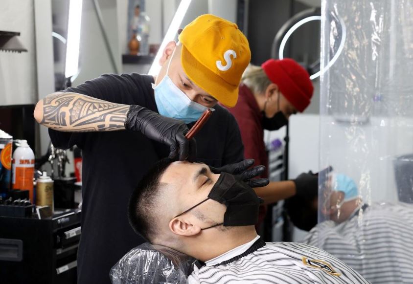 Barbers Mark DeGuzman, foreground, and Romel Diaz at their Hayward shop