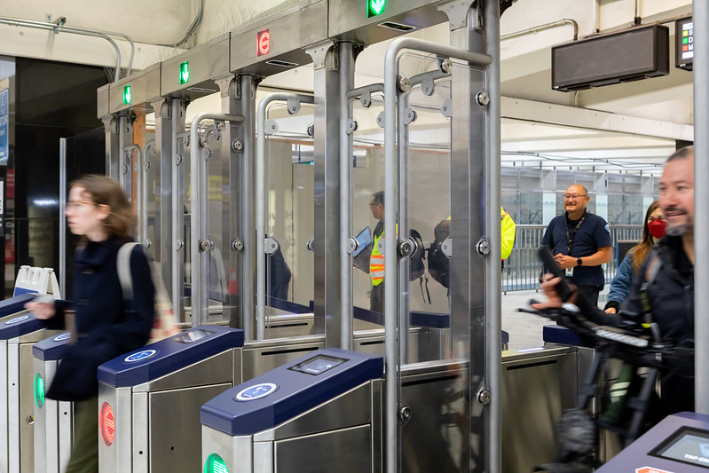 People enter and exit the new fare gates at Civic Center Station