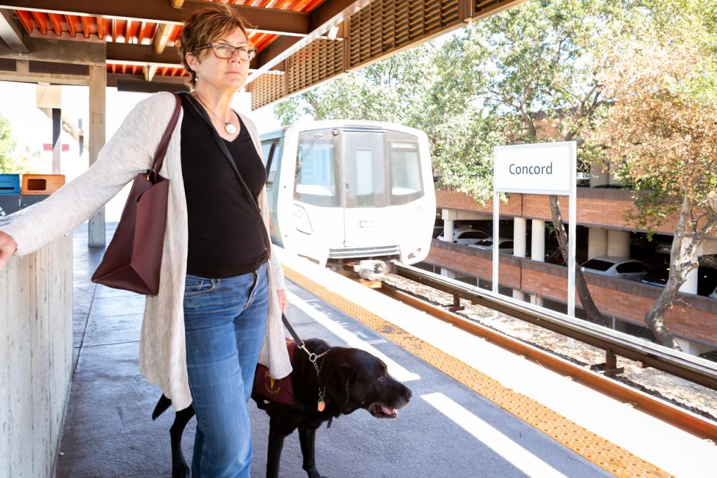 Kathleen Fraser and her service dog, Handsome Ransom, on the platform at Concord Station.  