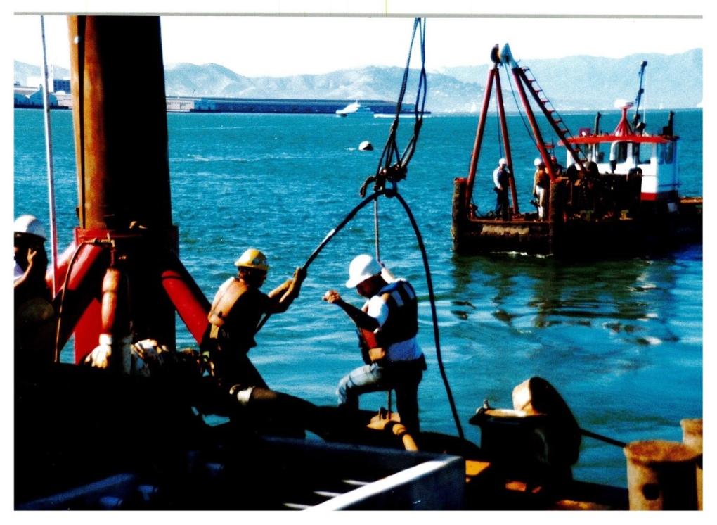 The crew on the barge handling cable. 