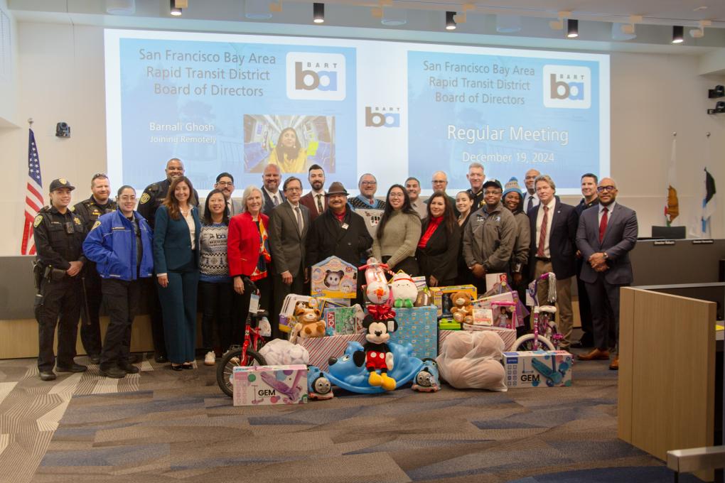 A photo of the BART board with BART staff and a pile of toys