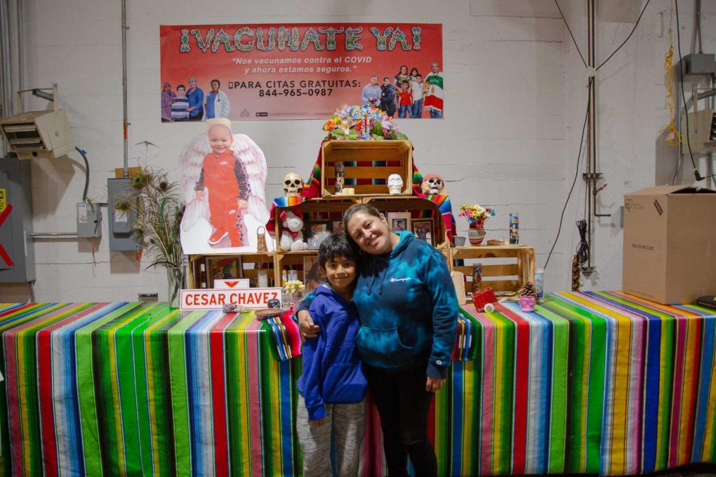 Marisol and her son in front of the altar at Mission Food Hub in San Francisco's Mission District.