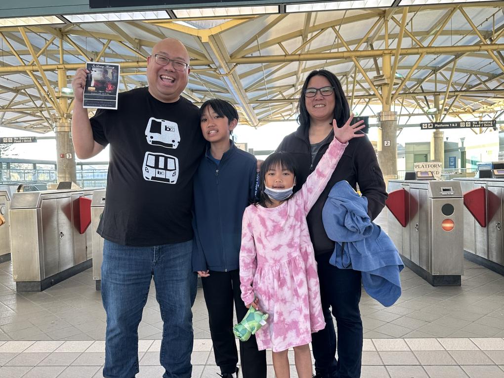 Mark and his family smile on the concourse at a BART station